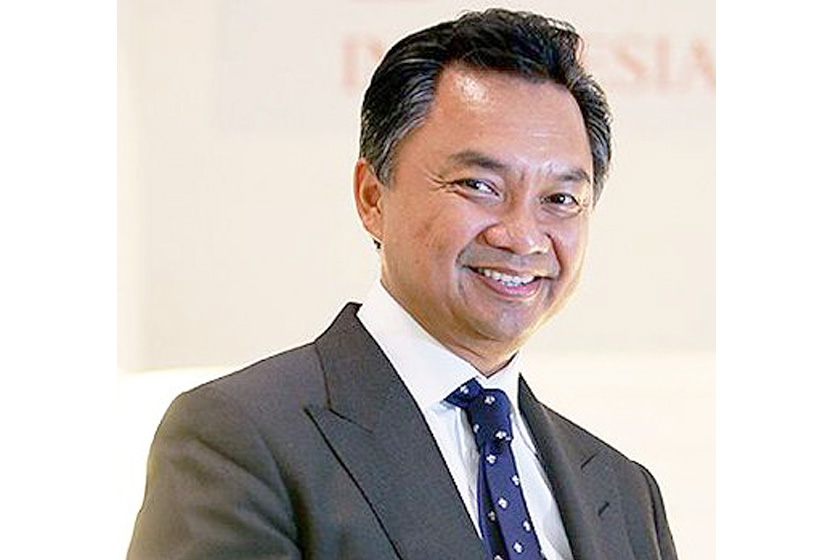 An older man with formal suit smiling